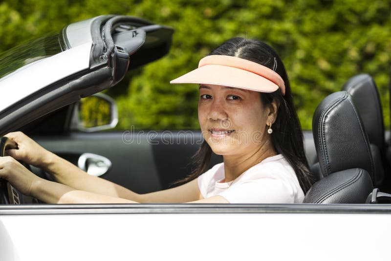 Mujer madura que se sienta en coche convertible en Niza día foto de archivo libre de regalías Mujer madura que se sienta en coche convertible en Niza día foto de archivo libre de regalías