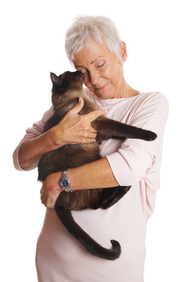 Mujer madura que sostiene el gato en sus brazos imagen de archivo