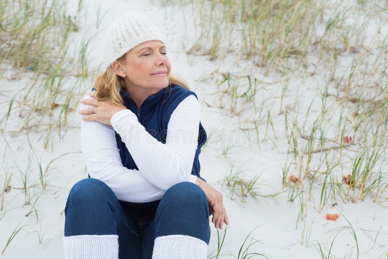 Mujer mayor con los ojos cerrados en la playa fotografía de archivo libre de regalías Mujer mayor con los ojos cerrados en la playa fotografía de archivo libre de regalías