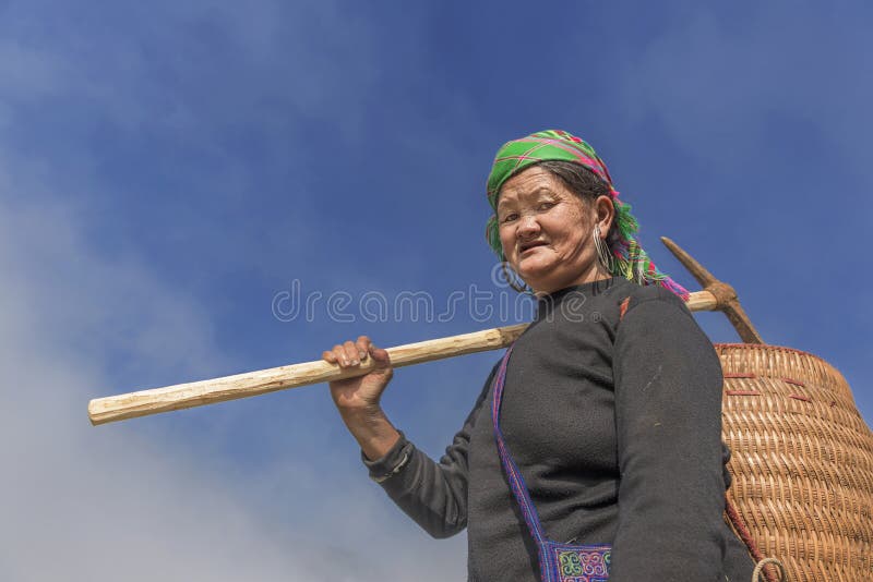 Mujer mayor de la tribu de Hmong en la manera a su campo de arroz en Sapa, Vietnam imagen de archivo Mujer mayor de la tribu de Hmong en la manera a su campo de arroz en Sapa, Vietnam imagen de archivo