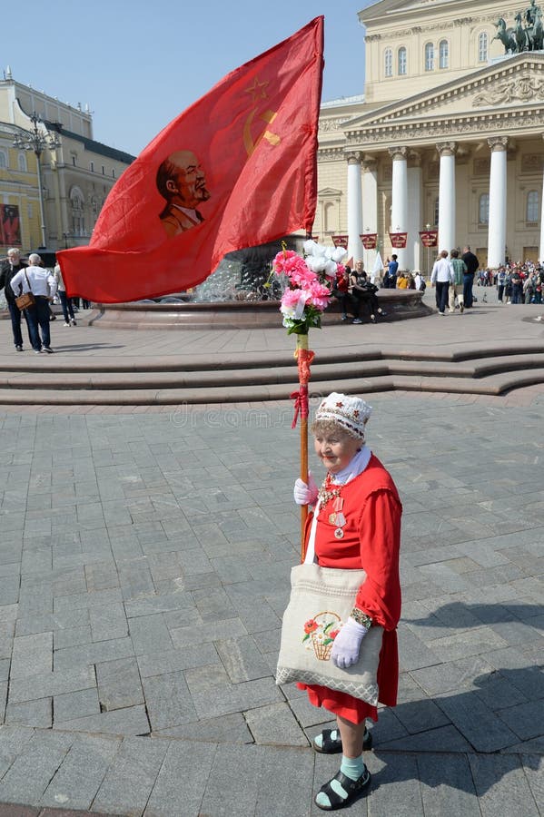 Mujer mayor desconocida con una bandera roja en el teatro de Moscú Bolshoi el día de la victoria imagen de archivo libre de regalías Mujer mayor desconocida con una bandera roja en el teatro de Moscú Bolshoi el día de la victoria imagen de archivo libre de regalías