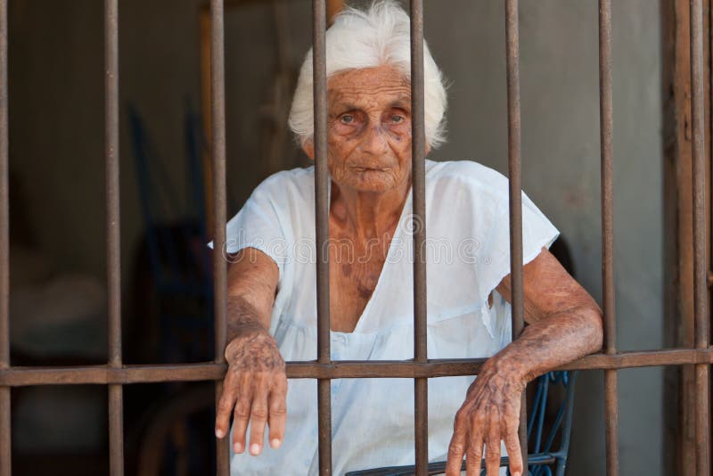 Mujer mayor detrás de barras fotografía de archivo libre de regalías Mujer mayor detrás de barras fotografía de archivo libre de regalías