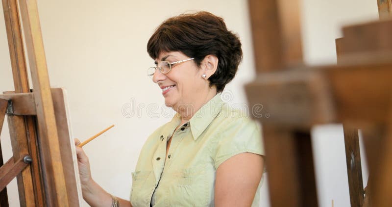 Mujer mayor que aprende pintar en Art Lesson imágenes de archivo libres de regalías Mujer mayor que aprende pintar en Art Lesson imágenes de archivo libres de regalías
