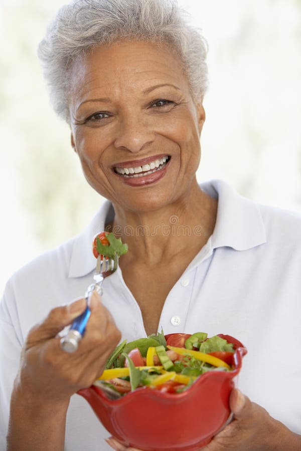 Mujer mayor que come una ensalada verde fresca imagen de archivo libre de regalías