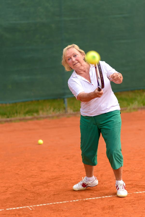 Mujer mayor que juega a tenis fotografía de archivo libre de regalías Mujer mayor que juega a tenis fotografía de archivo libre de regalías
