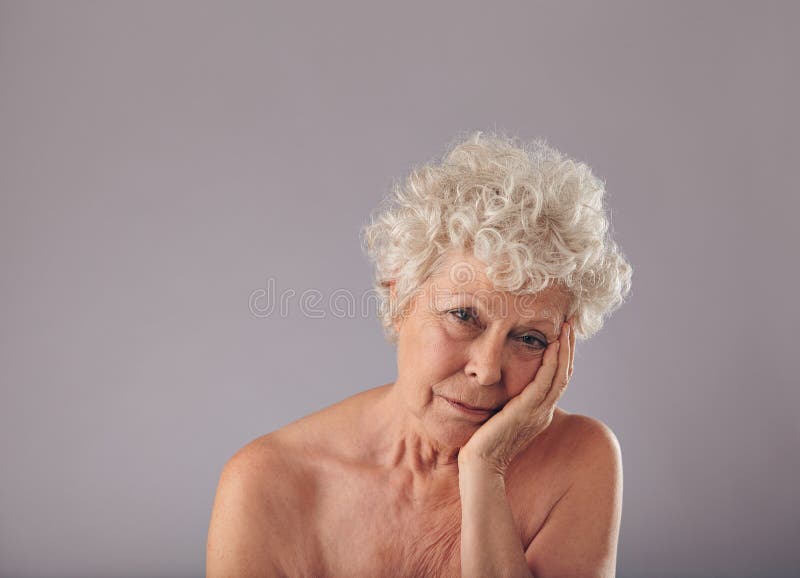 Mujer mayor trastornada en fondo gris fotografía de archivo libre de regalías Mujer mayor trastornada en fondo gris fotografía de archivo libre de regalías