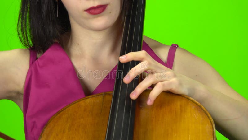 Mujer mete el violonchelo con los dedos Pantalla verde Cerrar