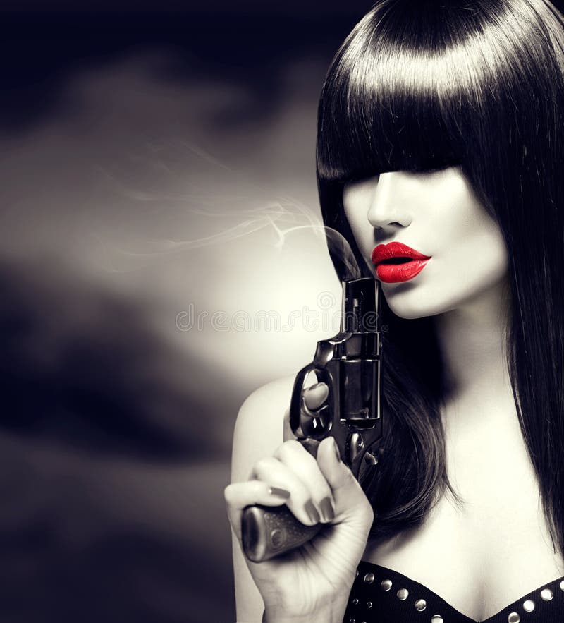 Mujer modelo atractiva con un arma