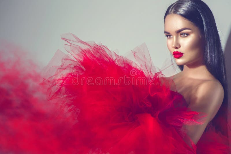 Mujer modelo morena magnífica en vestido rojo