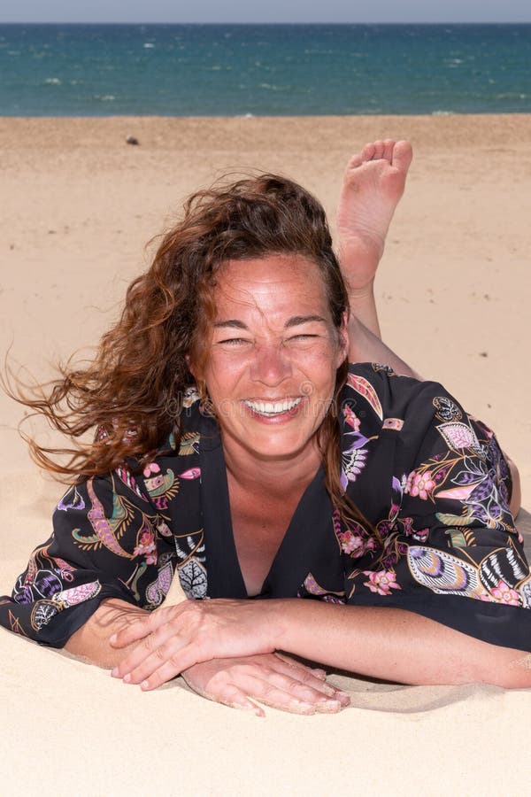 Mujer morena de moda en una sonrisa de la playa arenosa feliz imágenes de archivo libres de regalías Mujer morena de moda en una sonrisa de la playa arenosa feliz imágenes de archivo libres de regalías