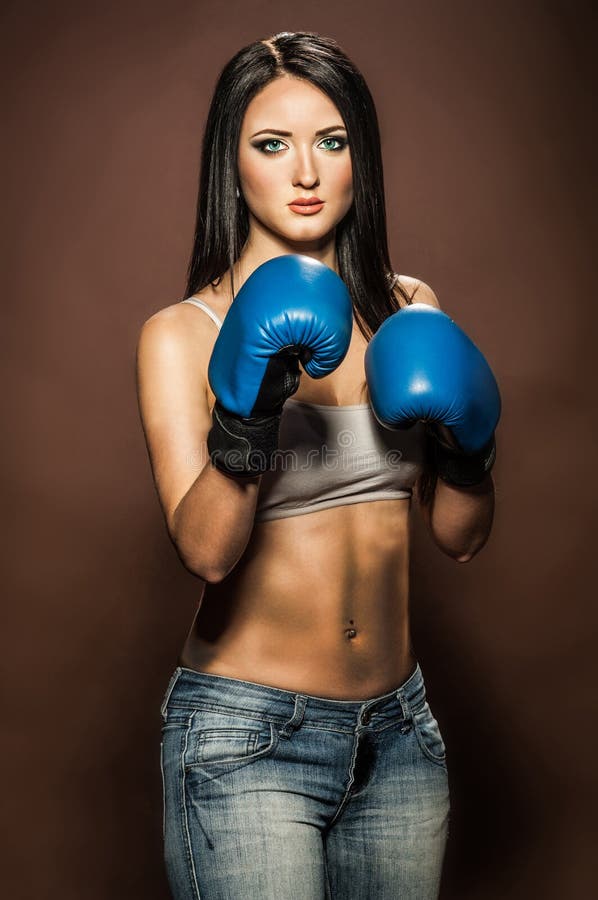 Mujer morena hermosa con los guantes de boxeo azules foto de archivo libre de regalías Mujer morena hermosa con los guantes de boxeo azules foto de archivo libre de regalías