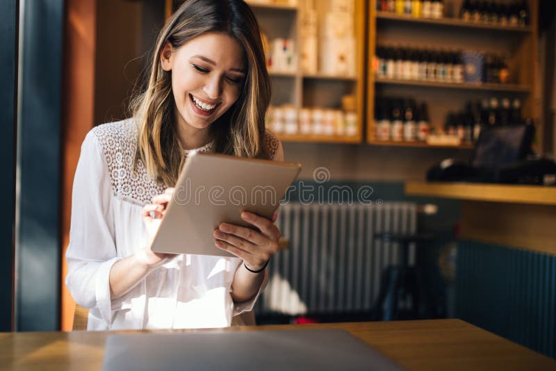 Mujer morena hermosa que usa el ordenador portátil en café foto de archivo Mujer morena hermosa que usa el ordenador portátil en café foto de archivo