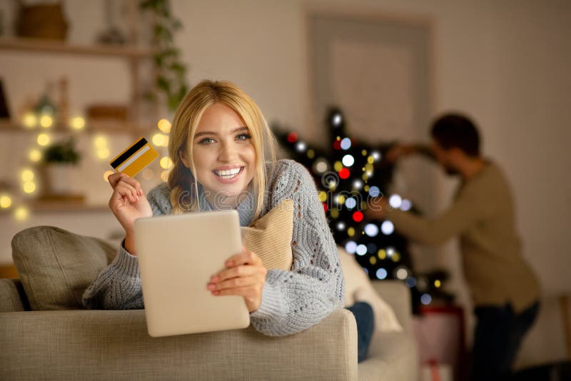 Mujer muy sonriente haciendo compras en línea en Navidad fotografía de archivo libre de regalías