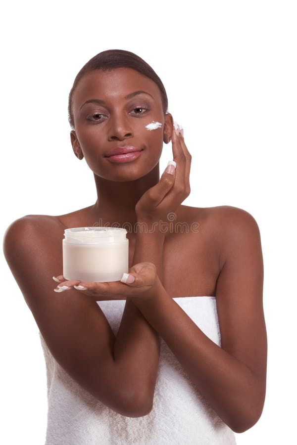 Mujer negra envuelta en cara hidratante de la toalla