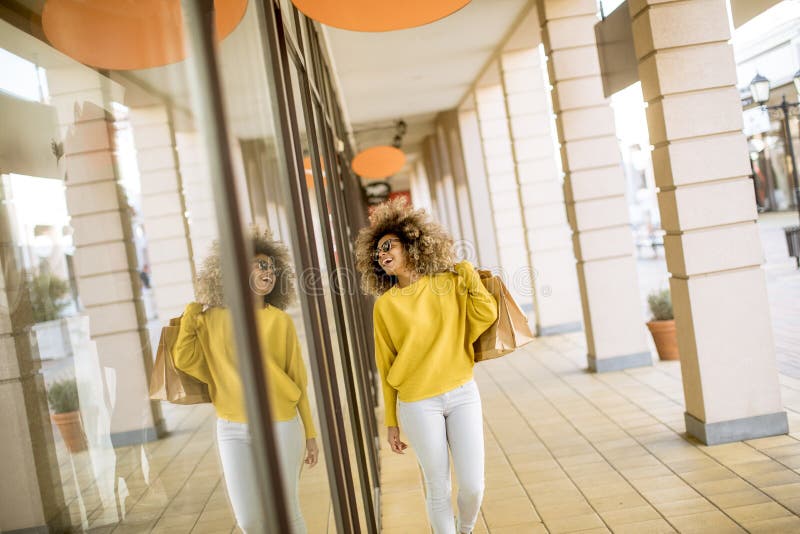 Mujer negra joven con el pelo rizado en compras fotografía de archivo libre de regalías Mujer negra joven con el pelo rizado en compras fotografía de archivo libre de regalías