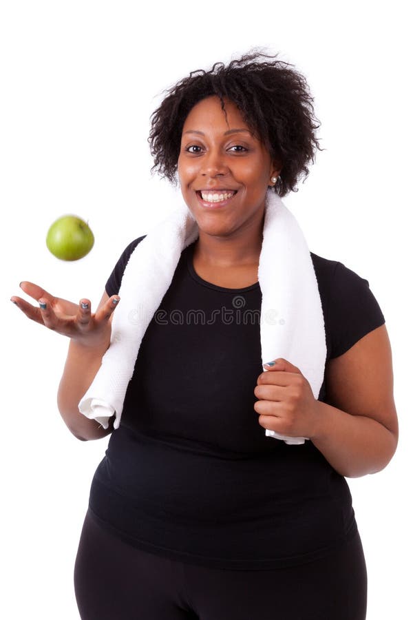 Mujer negra joven gorda que sostiene una manzana - gente africana fotografía de archivo libre de regalías