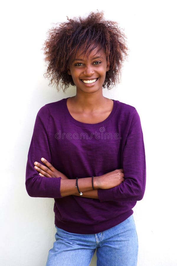 Mujer negra sonriente que se opone al fondo blanco imagen de archivo