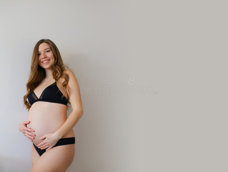 Mujer Norteamericana Embarazada Con Lencería Negra Sosteniendo Su Vientre Con Fondo De Copia Imagen de archivo - Imagen de interior, calma: 195138839