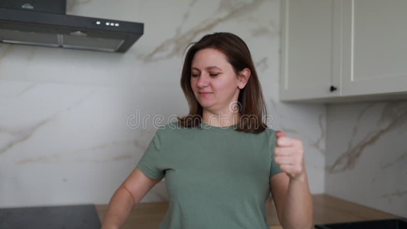 Mujer parada en la cocina sosteniendo las manos