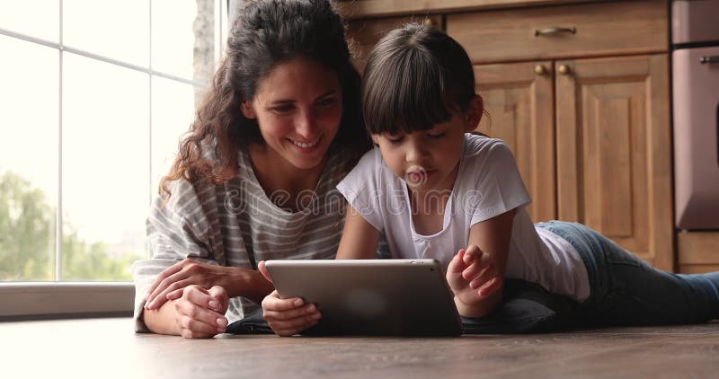 Mujer pasar el fin de semana con la pequeña hija adorable utilizando el dispositivo de la tableta