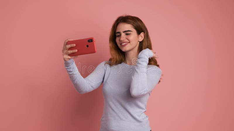 Mujer posando y sonriendo mientras se toma un selfie almacen de metraje de vídeo