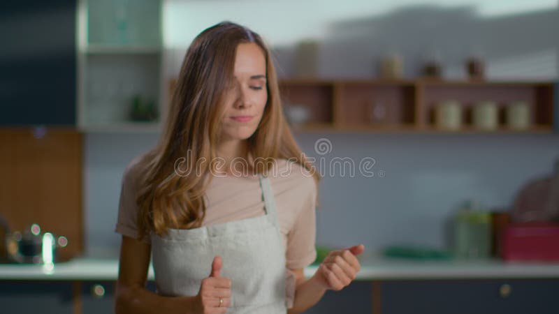 Mujer positiva bailando en cocina moderna Comedor de casa cocinando en la cocina