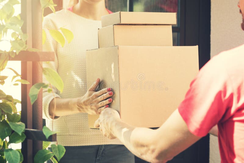 Mujer que acepta un servicio a domicilio de cajas del repartidor fotos de archivo libres de regalías Mujer que acepta un servicio a domicilio de cajas del repartidor fotos de archivo libres de regalías