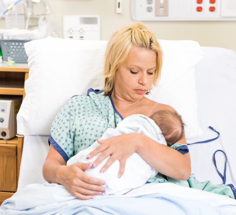Mujer que amamanta Babygirl recién nacido en hospital imagenes de archivo Mujer que amamanta Babygirl recién nacido en hospital imagenes de archivo
