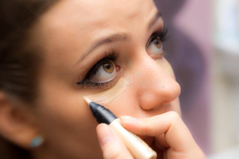 Mujer que aplica maquillaje imágenes de archivo libres de regalías Mujer que aplica maquillaje imágenes de archivo libres de regalías