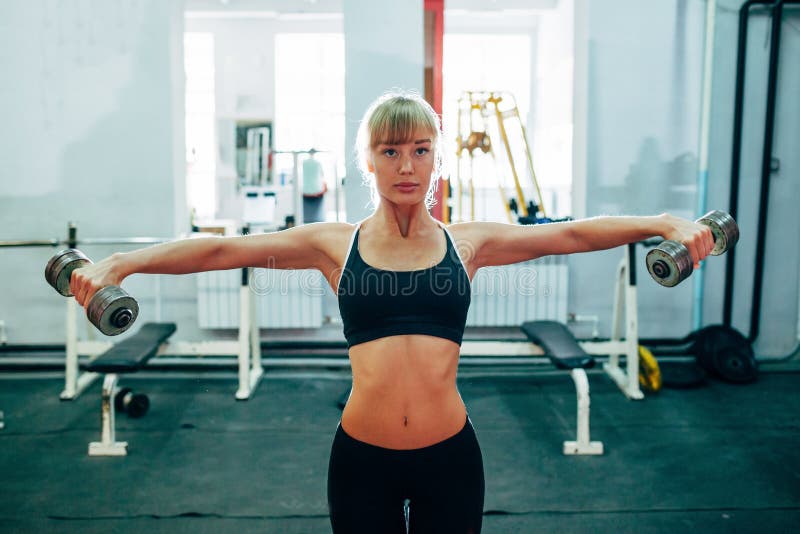 Mujer que aumenta pesas de gimnasia en el gimnasio imágenes de archivo libres de regalías Mujer que aumenta pesas de gimnasia en el gimnasio imágenes de archivo libres de regalías