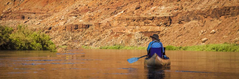 Mujer que bate la canoa en el río del desierto