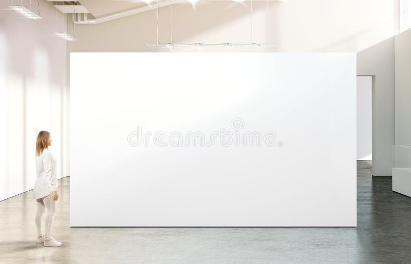 Mujer que camina cerca de maqueta blanca en blanco de la pared en galería moderna