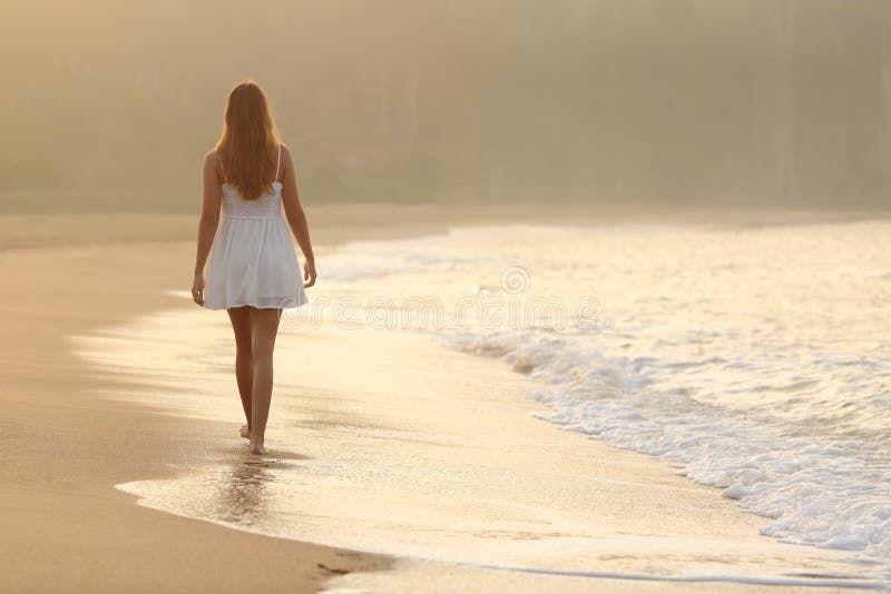 Mujer que camina en la arena de la playa foto de archivo libre de regalías Mujer que camina en la arena de la playa foto de archivo libre de regalías