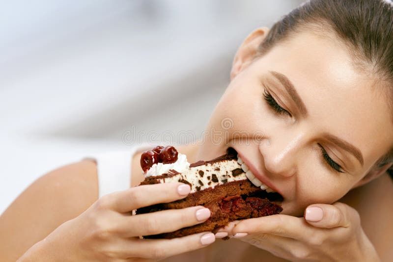 Mujer que come la torta Postre femenino hermoso de la consumición imágenes de archivo libres de regalías