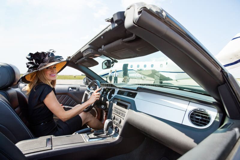 Mujer que conduce el convertible hacia Jet At privada foto de archivo Mujer que conduce el convertible hacia Jet At privada foto de archivo