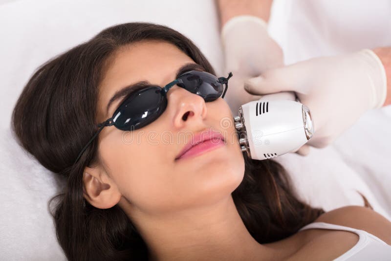 Laser Para Mejorar La Piel Mujer Que Consigue Un Tratamiento De La Piel Del Laser Foto de archivo