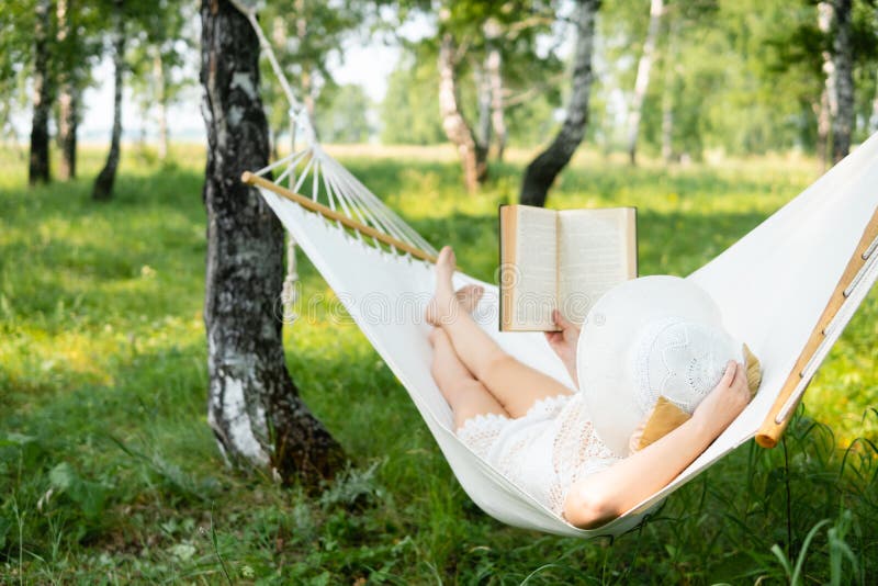 Mujer que descansa en hamaca al aire libre Relájese y leyendo el libro fotos de archivo libres de regalías Mujer que descansa en hamaca al aire libre Relájese y leyendo el libro fotos de archivo libres de regalías
