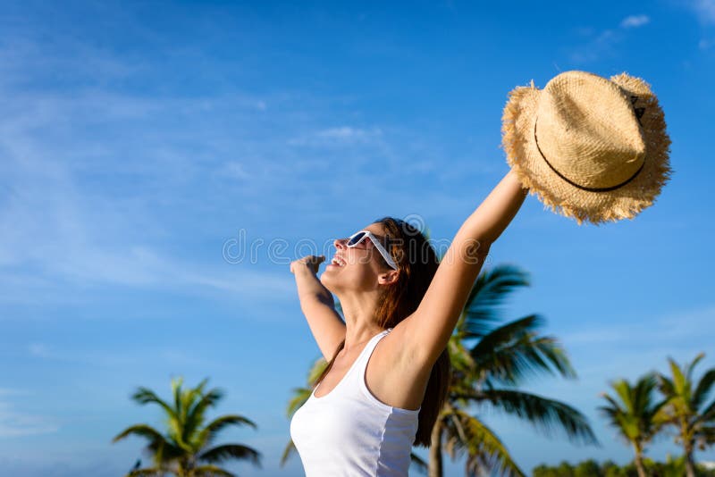 Blissful woman on tropical caribbean vacation raising arms to the sky. Freedom and travel concept. Brunette woman enjoying summer holidays. Blissful woman on tropical caribbean vacation raising arms to the sky. Freedom and travel concept. Brunette woman enjoying summer holidays.