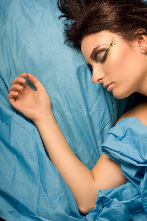 Mujer que duerme en ropas de cama azules