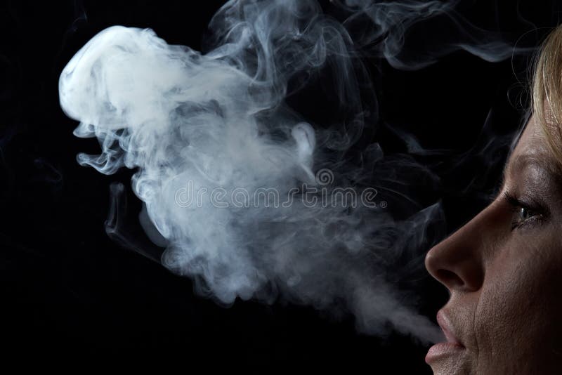 Mujer que exhala humo foto de archivo Mujer que exhala humo foto de archivo