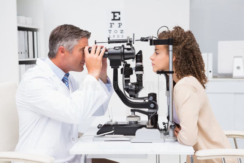 Mujer que hace la prueba del ojo con el optometrista