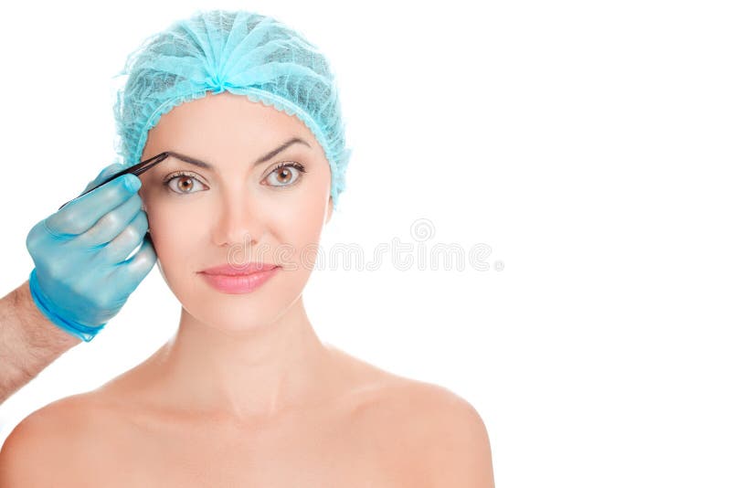 Mujer que hace pelo de las cejas desplumar por la mano del doctor fotos de archivo libres de regalías Mujer que hace pelo de las cejas desplumar por la mano del doctor fotos de archivo libres de regalías