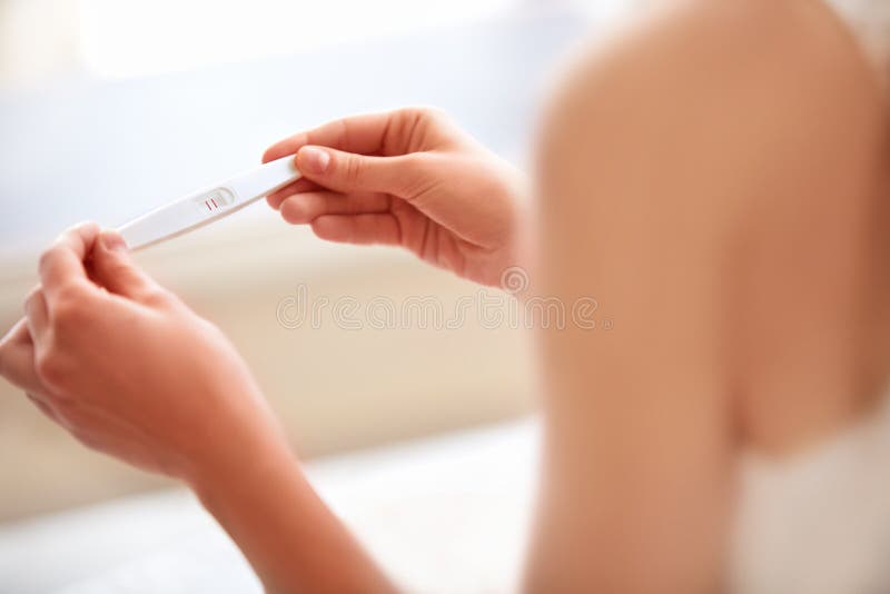 Mujer que lleva a cabo la prueba de embarazo embarazada imagenes de archivo