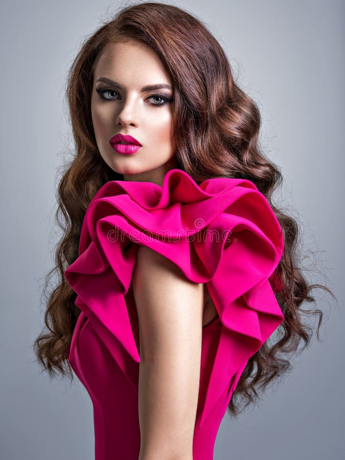 Mujer que lleva el vestido rojo de moda con un peinado creativo fotografía de archivo libre de regalías