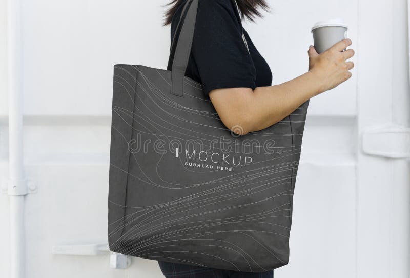 Mujer que lleva una maqueta negra del bolso que hace compras imagen de archivo libre de regalías Mujer que lleva una maqueta negra del bolso que hace compras imagen de archivo libre de regalías