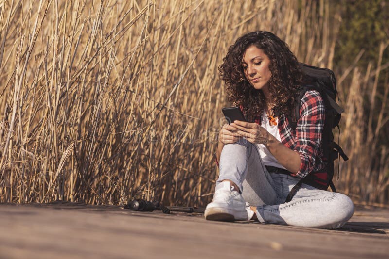 Mujer que mecanografía un mensaje de texto al aire libre imagenes de archivo Mujer que mecanografía un mensaje de texto al aire libre imagenes de archivo