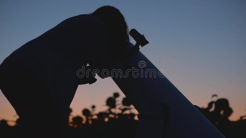 Mujer que mira a la luna a trav?s del telescopio