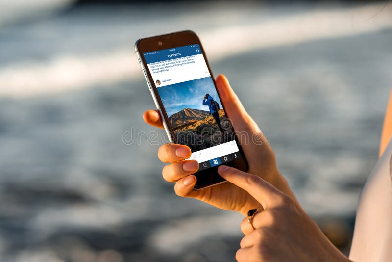 Mujer que mira las noticias de Instagram con nuevo iPhone fotos de archivo Mujer que mira las noticias de Instagram con nuevo iPhone fotos de archivo