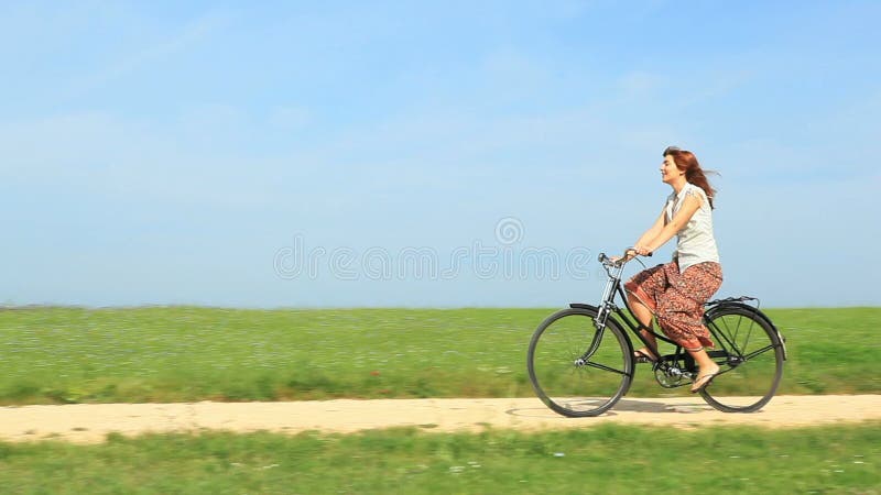 Mujer que monta una bici del vintage en una mañana de la primavera almacen de video