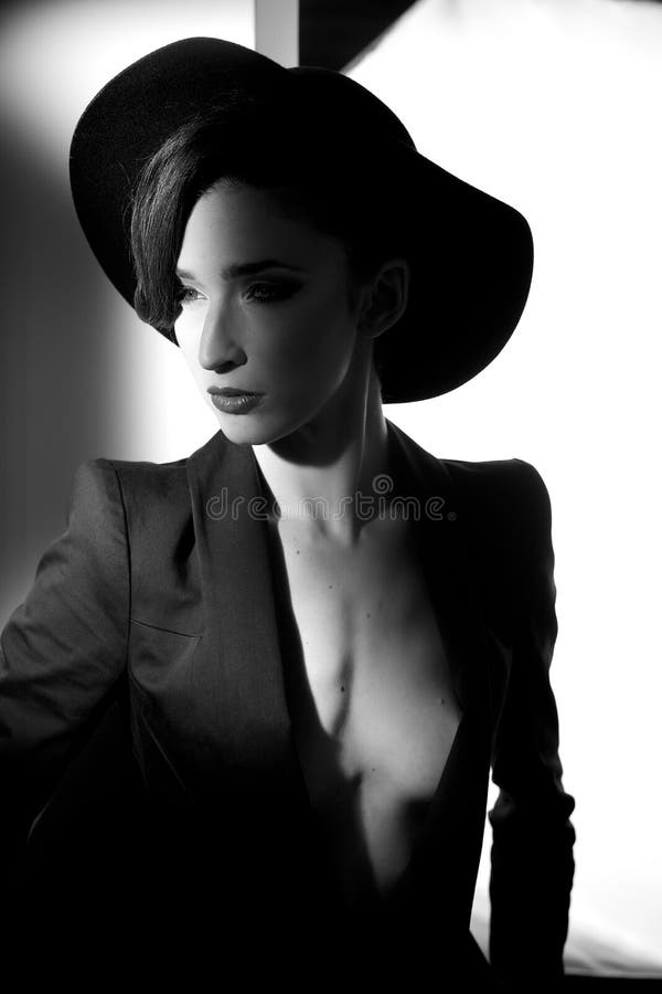 Mujer que presenta para el lanzamiento de la moda con fuerte desnudo de la chaqueta del sombrero foto de archivo Mujer que presenta para el lanzamiento de la moda con fuerte desnudo de la chaqueta del sombrero foto de archivo
